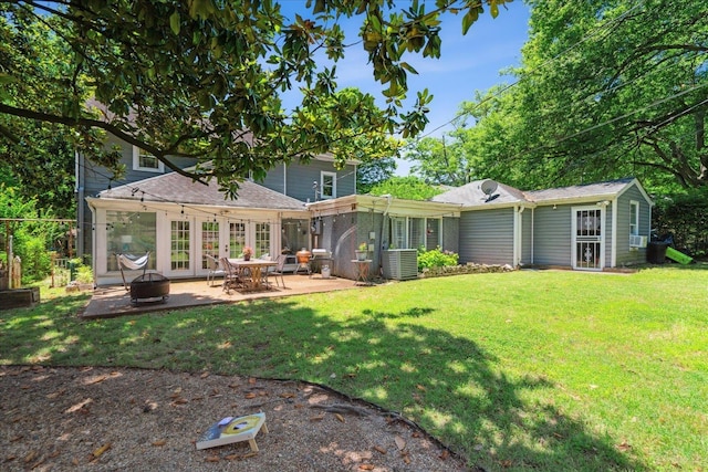 rear view of house featuring central AC unit, a lawn, and a patio area