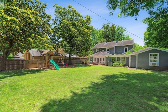 view of yard featuring central air condition unit, a fenced backyard, and a playground