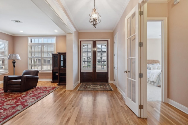 entryway featuring light wood-style floors, visible vents, crown molding, and french doors