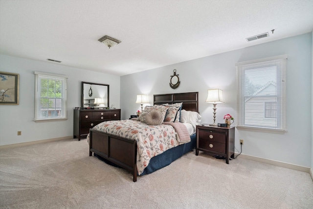 bedroom with carpet floors, visible vents, and baseboards