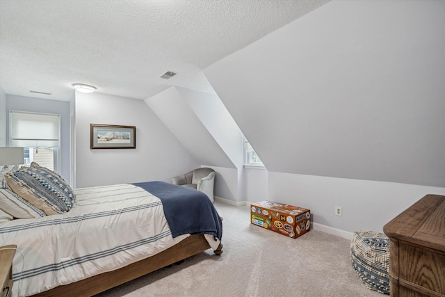 bedroom featuring carpet floors, visible vents, vaulted ceiling, a textured ceiling, and baseboards