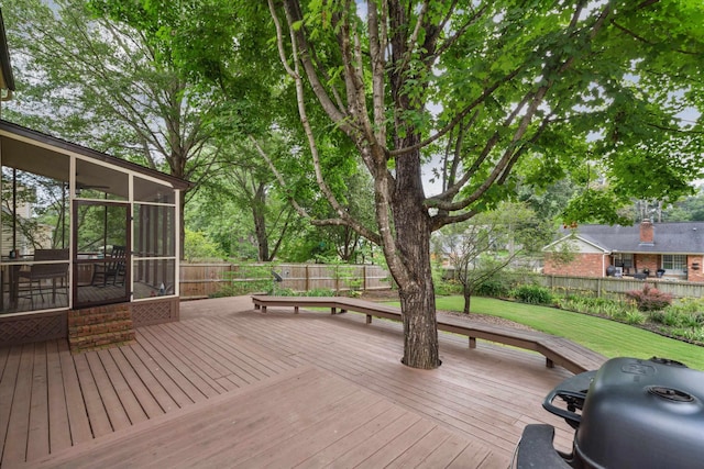 wooden deck with a sunroom, a fenced backyard, a yard, and area for grilling