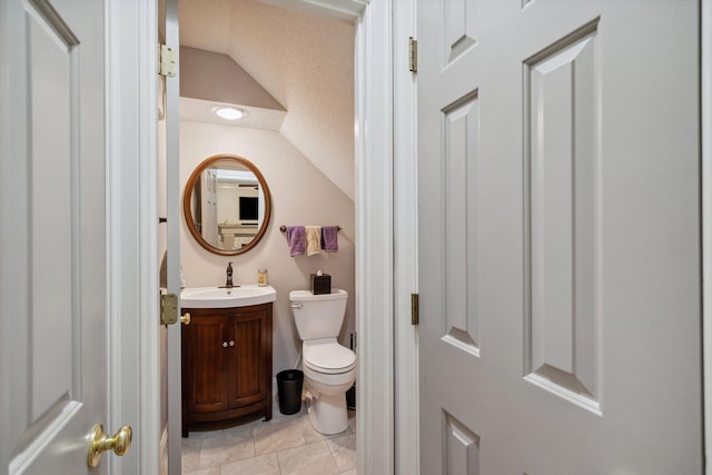 bathroom featuring vaulted ceiling, vanity, and toilet