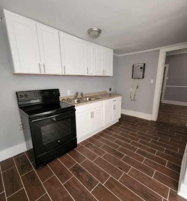 kitchen featuring wood finish floors, black electric range, white cabinetry, and a sink