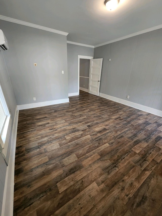 unfurnished room featuring dark wood finished floors, an AC wall unit, crown molding, and baseboards