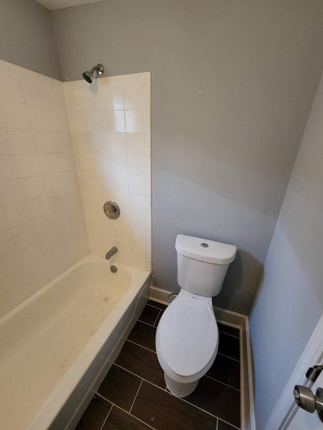 bathroom featuring  shower combination, toilet, and tile patterned floors