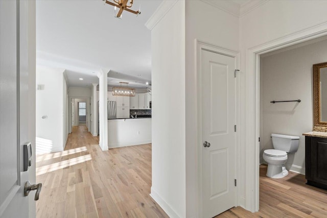 bathroom featuring toilet, wood finished floors, vanity, tasteful backsplash, and crown molding