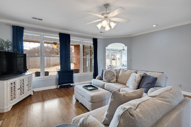 living area featuring a ceiling fan, arched walkways, visible vents, and wood finished floors