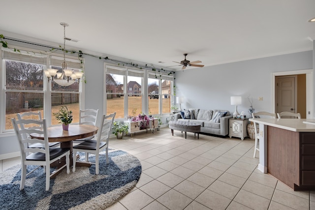 dining space featuring light tile patterned flooring, visible vents, baseboards, and ceiling fan with notable chandelier