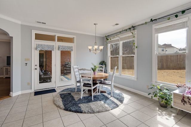 dining space featuring arched walkways, visible vents, crown molding, and light tile patterned floors