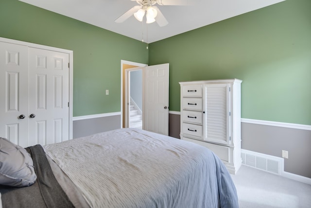 carpeted bedroom featuring a ceiling fan, a closet, visible vents, and baseboards