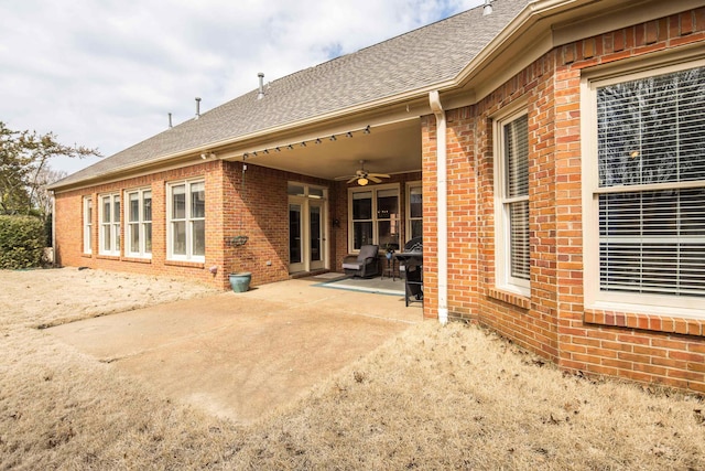 back of house with a shingled roof, a patio area, brick siding, and ceiling fan