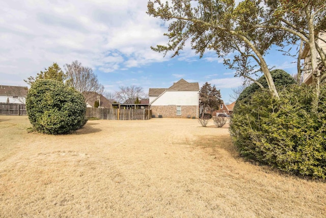 view of yard featuring driveway and fence