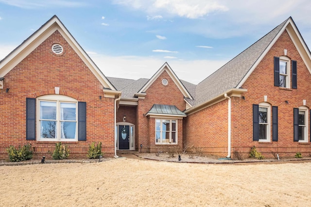 traditional-style house with brick siding and roof with shingles