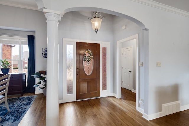 foyer featuring decorative columns, dark wood finished floors, visible vents, and baseboards