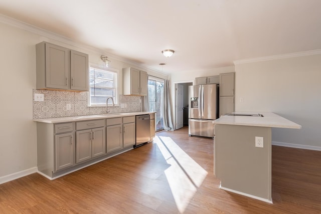 kitchen featuring gray cabinets, decorative backsplash, stainless steel appliances, and light countertops