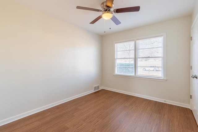 unfurnished room featuring visible vents, ceiling fan, baseboards, and wood finished floors