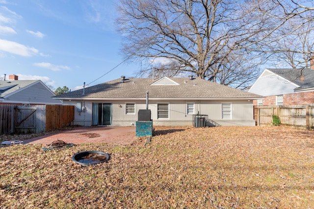 back of property featuring an outdoor fire pit, a fenced backyard, central AC, brick siding, and a patio area