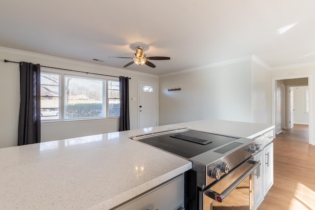 kitchen featuring light stone counters, white cabinetry, light wood-style floors, ornamental molding, and stainless steel electric range