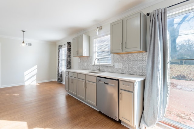 kitchen featuring light wood-style flooring, a sink, gray cabinets, dishwasher, and tasteful backsplash