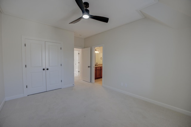 unfurnished bedroom featuring ceiling fan, baseboards, a closet, and light colored carpet