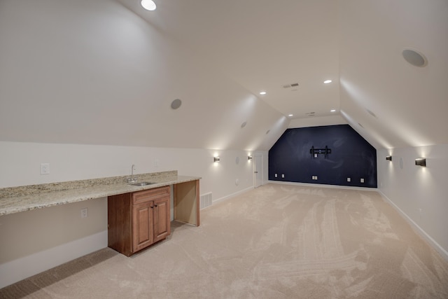 cinema room featuring visible vents, vaulted ceiling, a sink, and light colored carpet