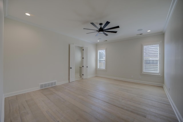 unfurnished room with baseboards, light wood finished floors, visible vents, and crown molding