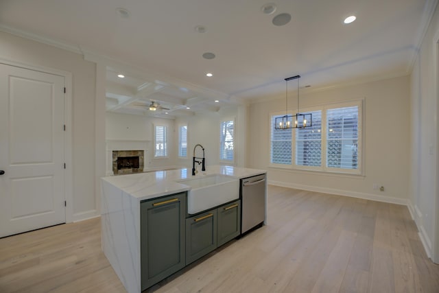 kitchen featuring a sink, a high end fireplace, light wood-style floors, open floor plan, and dishwasher