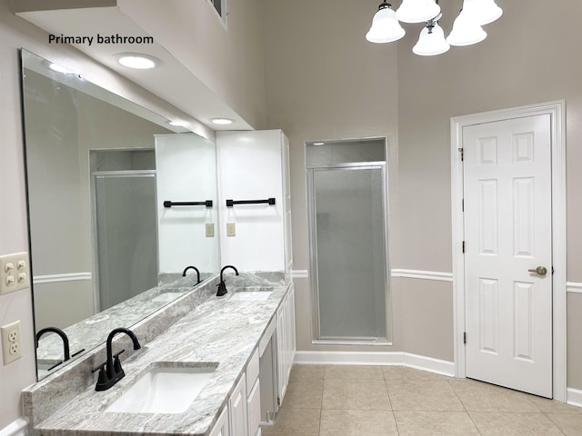 bathroom featuring a stall shower, a sink, and tile patterned floors