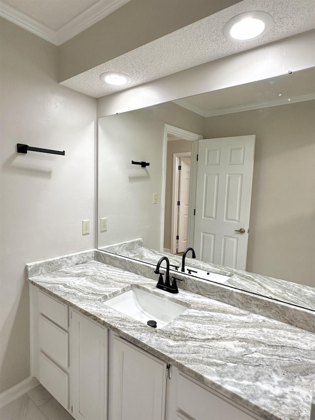 bathroom with a textured ceiling, vanity, baseboards, marble finish floor, and crown molding