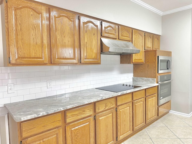 kitchen with light tile patterned floors, stainless steel appliances, crown molding, under cabinet range hood, and backsplash