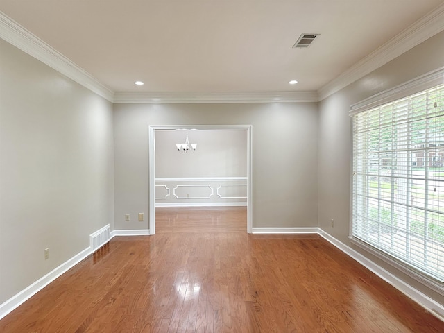 unfurnished room with a chandelier, visible vents, plenty of natural light, and wood finished floors