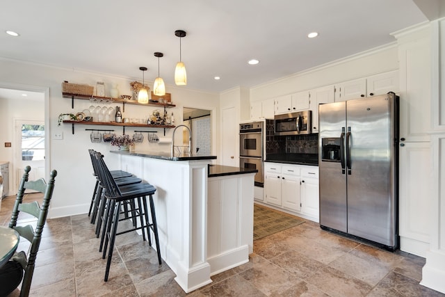 kitchen featuring stainless steel appliances, dark countertops, a peninsula, and white cabinetry