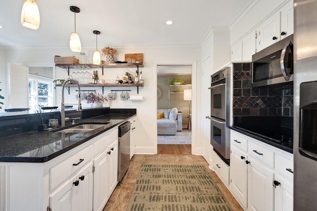 kitchen featuring white cabinetry, appliances with stainless steel finishes, a sink, and ornamental molding