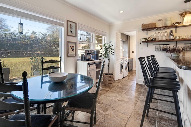 dining area featuring baseboards, separate washer and dryer, and crown molding