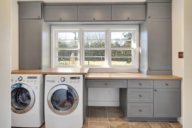 laundry area with separate washer and dryer, stone finish floor, cabinet space, and a healthy amount of sunlight