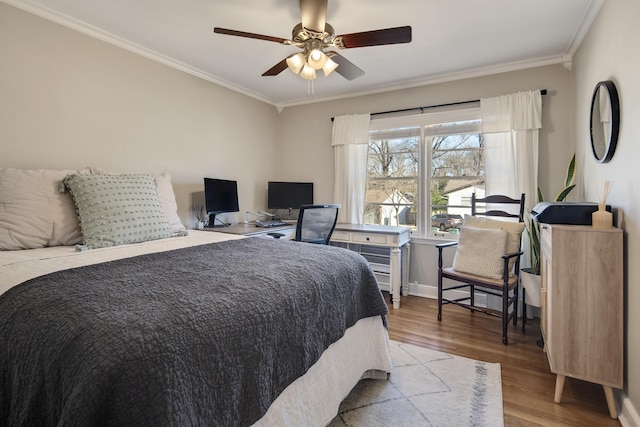 bedroom featuring ornamental molding, a ceiling fan, baseboards, and wood finished floors