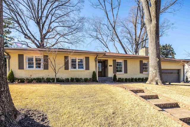 single story home with a front lawn, brick siding, a chimney, and an attached garage