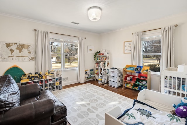 interior space with visible vents, crown molding, baseboards, and wood finished floors