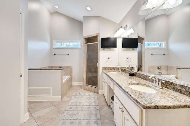 bathroom featuring a garden tub, lofted ceiling, a sink, a shower stall, and plenty of natural light