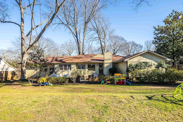 ranch-style house with brick siding, a chimney, fence, and a front yard