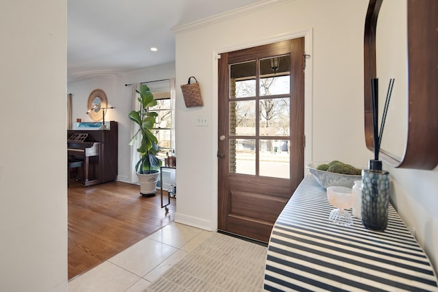 entryway with light tile patterned floors, baseboards, ornamental molding, and recessed lighting