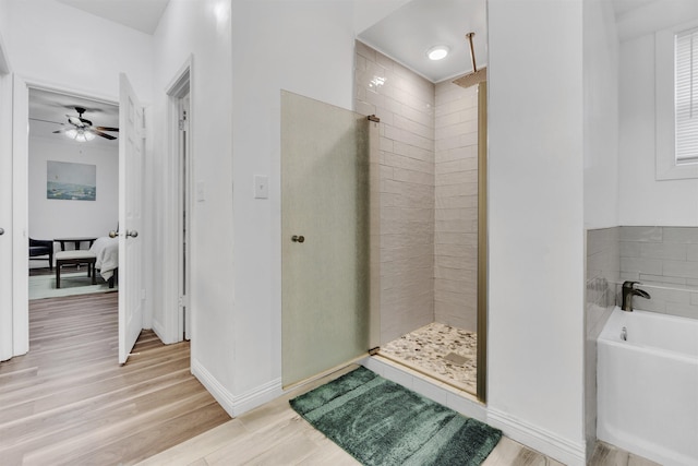 ensuite bathroom with a stall shower, baseboards, connected bathroom, wood finished floors, and a bath