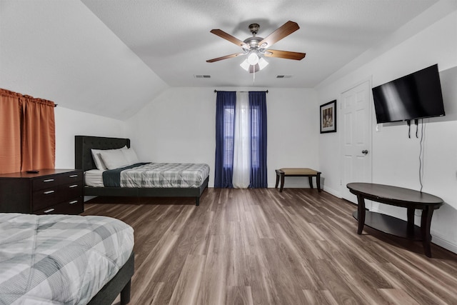 bedroom featuring vaulted ceiling, wood finished floors, and visible vents