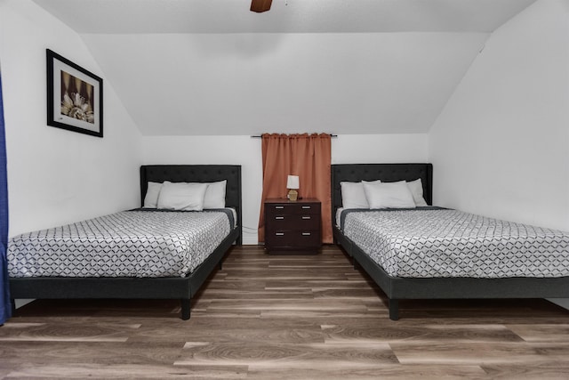 bedroom featuring a ceiling fan, lofted ceiling, and wood finished floors