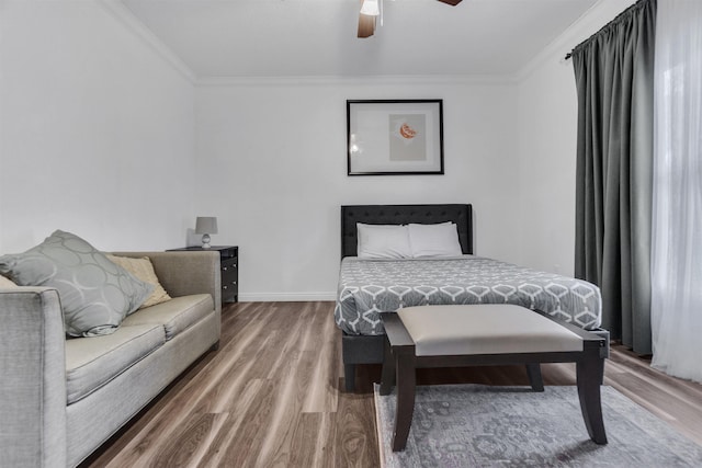 bedroom featuring ornamental molding, ceiling fan, baseboards, and wood finished floors