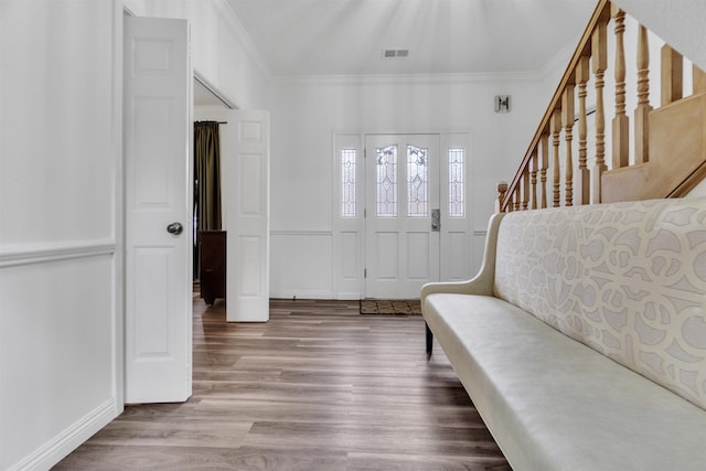 entryway featuring stairs, wood finished floors, visible vents, and crown molding