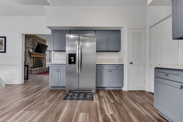 kitchen with gray cabinets, stainless steel refrigerator with ice dispenser, and wood finished floors