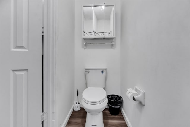 bathroom with baseboards, toilet, and wood finished floors