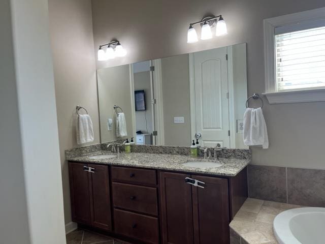 full bathroom with a tub, tile patterned floors, a sink, and double vanity